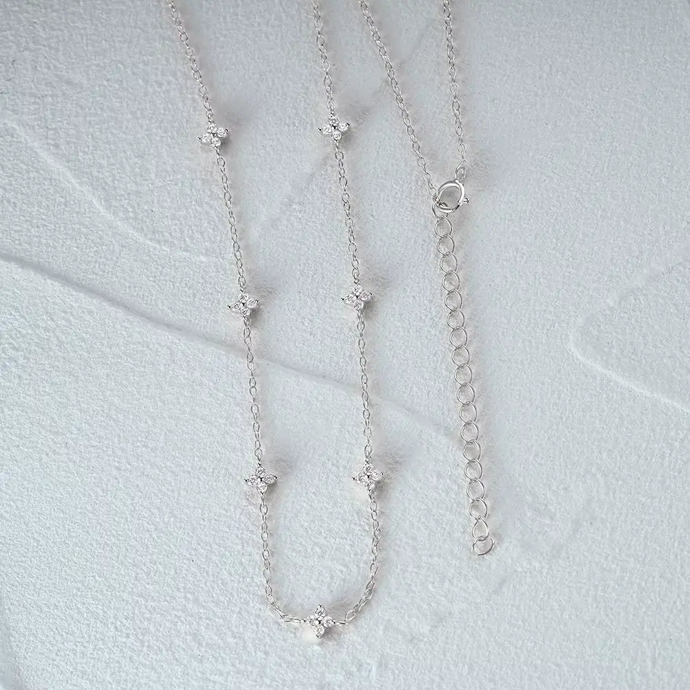 Collier fleurs chaîne forçat en argent 925 plaqué or blanc et zircons naturels à plat vue de face.