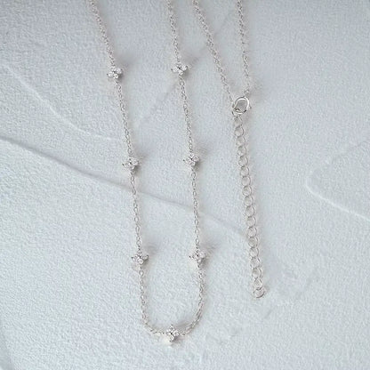 Collier fleurs chaîne forçat en argent 925 plaqué or blanc et zircons naturels à plat vue de face.