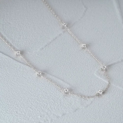 Collier fleurs chaîne forçat en argent 925 plaqué or blanc et zircons naturels à plat vue de côté.