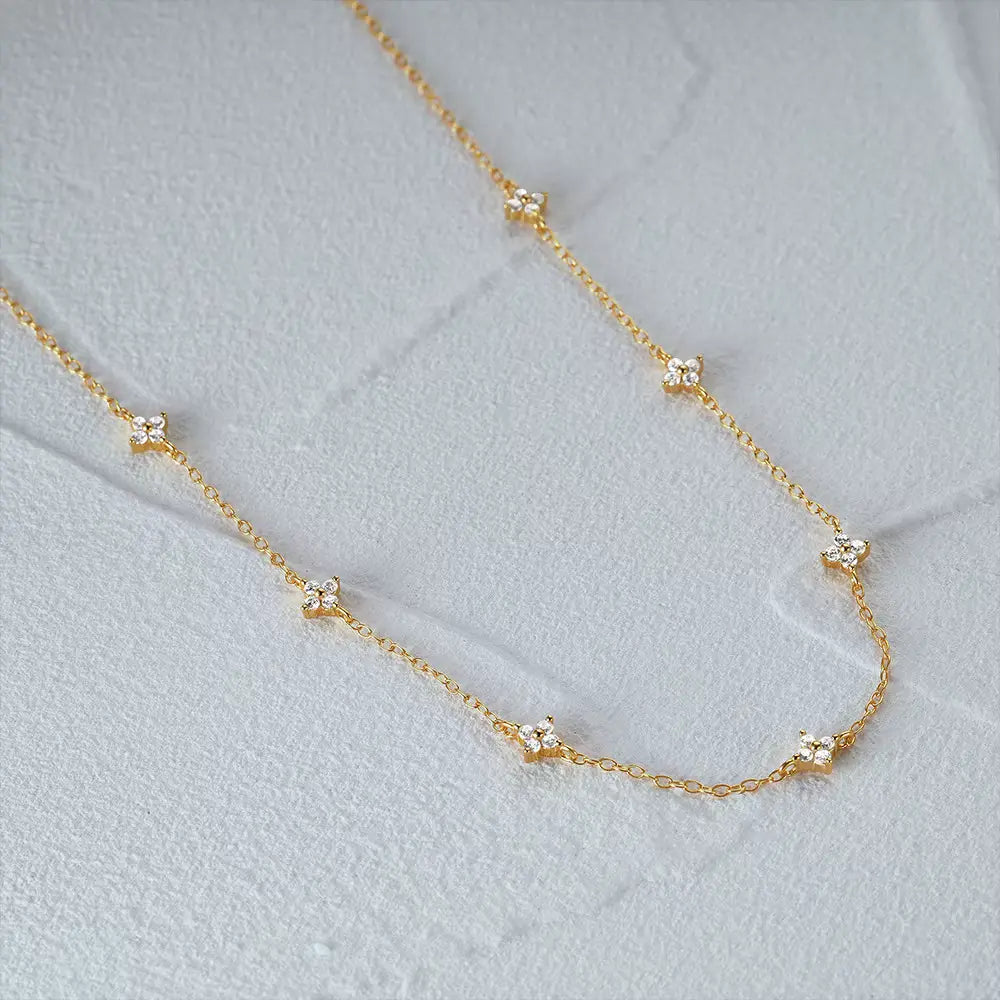 Collier fleurs maille forçat anitha en argent 925 plaqué or jaune et diamants à plat vue de côté.