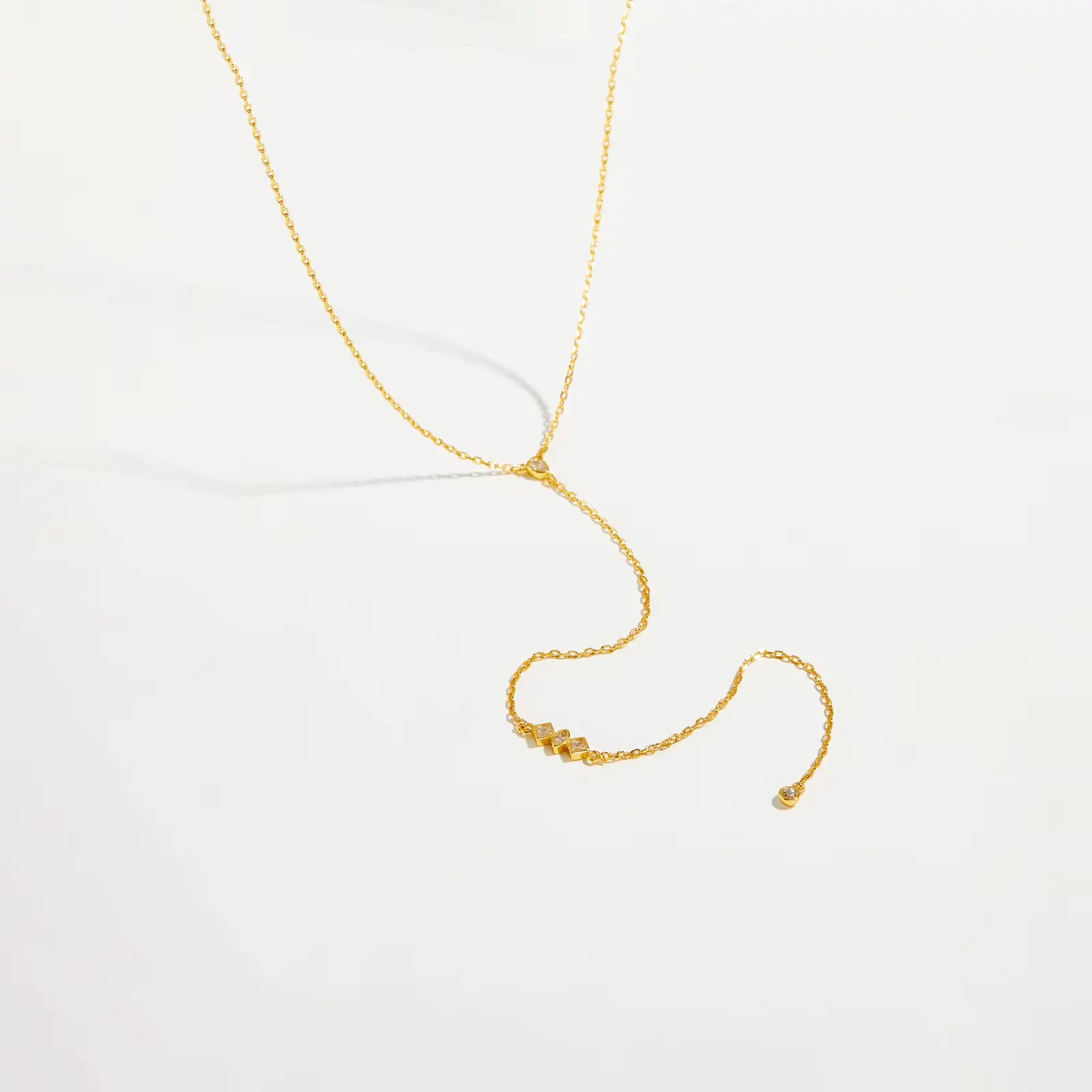 Collier long pendentif chaîne doré en argent 925 plaqué or jaune et diamants scintillants posé.