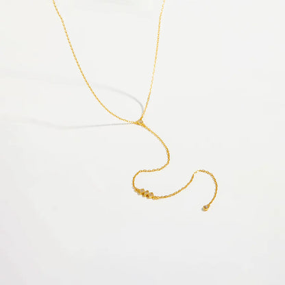Collier long pendentif chaîne doré en argent 925 plaqué or jaune et diamants scintillants posé.
