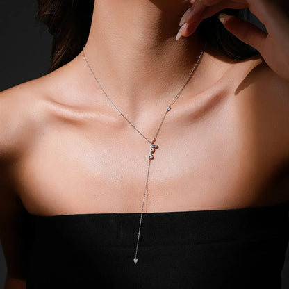 Collier love long pendentif cœur en argent 925 plaqué or blanc et diamants en zircon naturel blancs et roses porté au cou d'une femme.