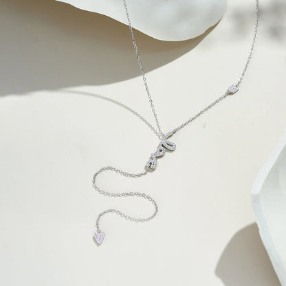 Collier love long pendentif cœur en argent 925 plaqué or blanc délicat et diamants blanc et roses posé.