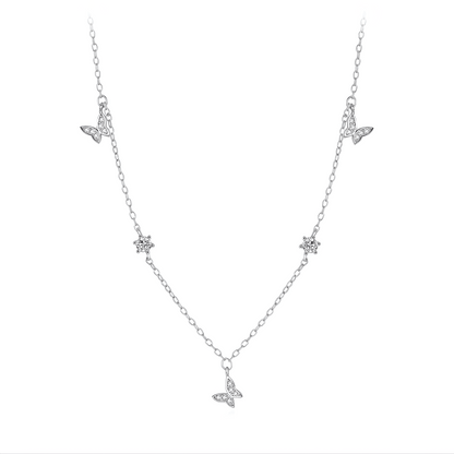 Collier maille argentée papillons en argent 925 plaqué or blanc et zircons sur fond blanc.
