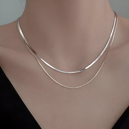 Collier multi-chaînes Aria en argent sterling 925 porté au cou d'une femme vue de proche.