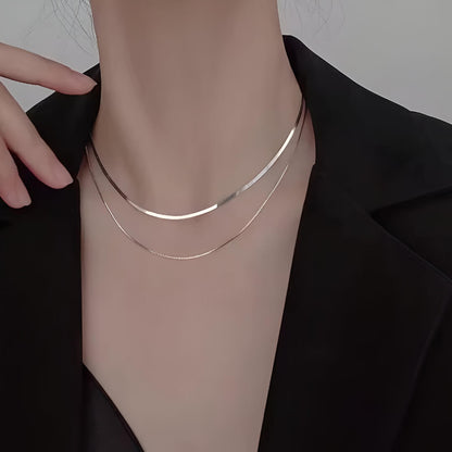 Collier multichaîne en argent 925 porté au cou d'une femme.