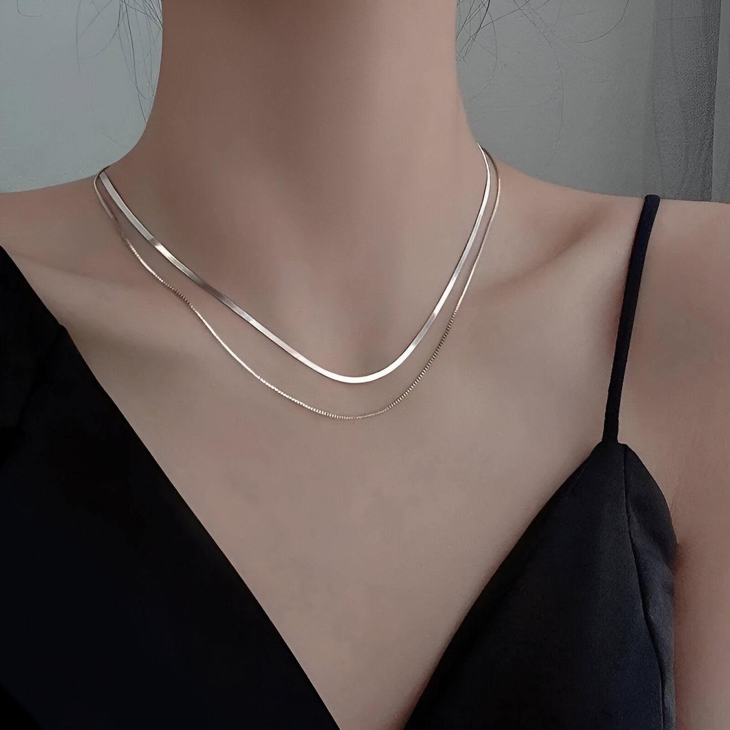 Collier multichaîne en argent 925 porté au cou d'une femme vue de loin.