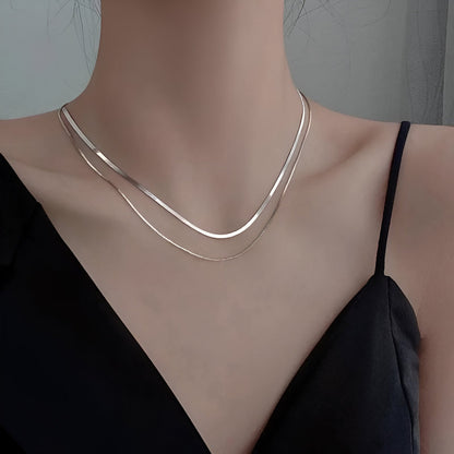 Collier multichaîne en argent 925 porté au cou d'une femme vue de loin.