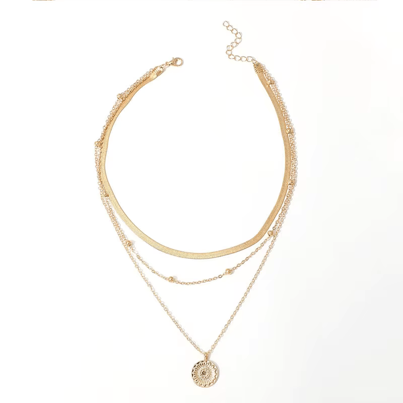 Collier multichaîne en or jaune sur fond blanc.