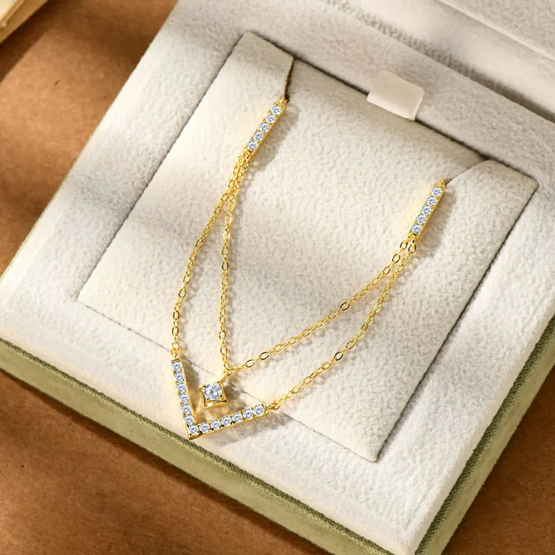Collier multi-chaînes pendentif V en argent 925 plaqué or jaune chaleureux et diamants rangé dans son écrin vue de face.