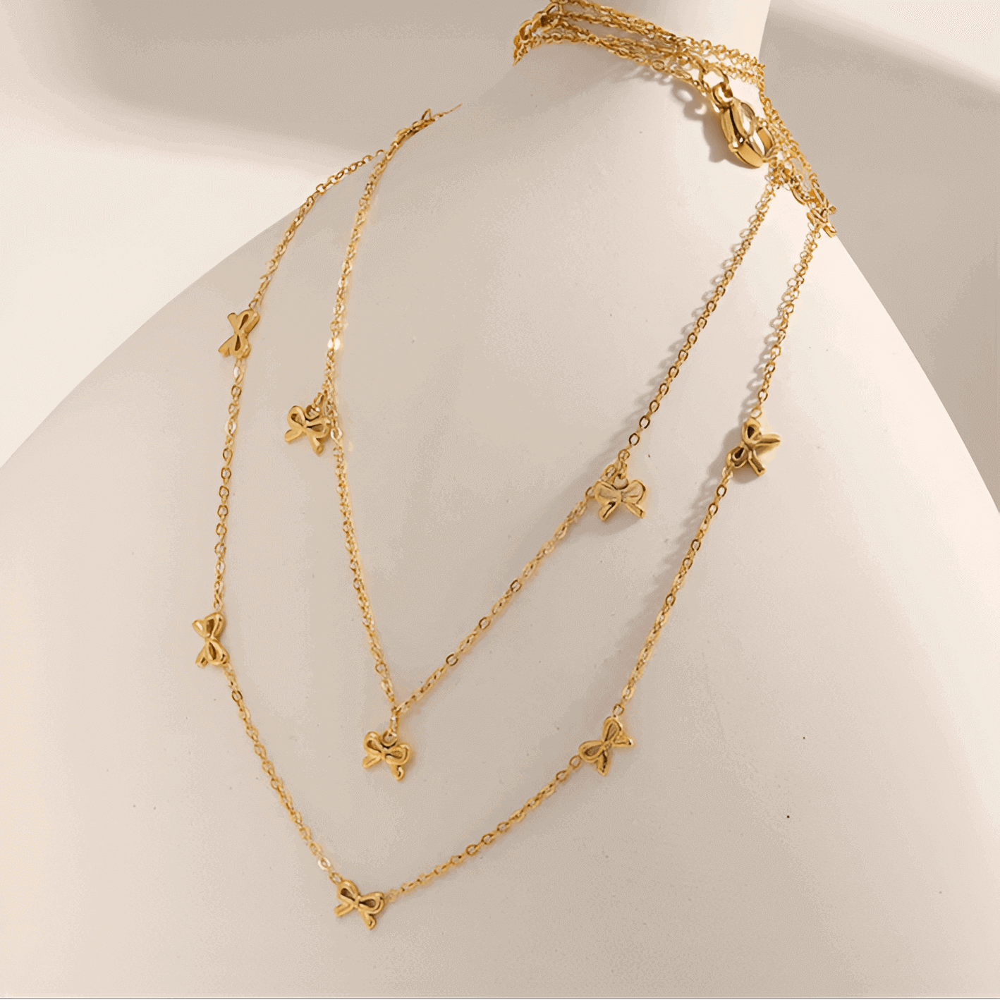 Collier nœud papillon en acier inoxydable plaqué or jaune variantes breloques et incrusté sur une jarre.