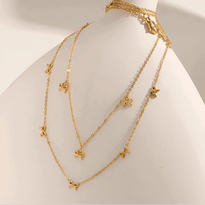 Collier nœud papillon en acier inoxydable plaqué or jaune variantes breloques et incrusté sur une jarre.