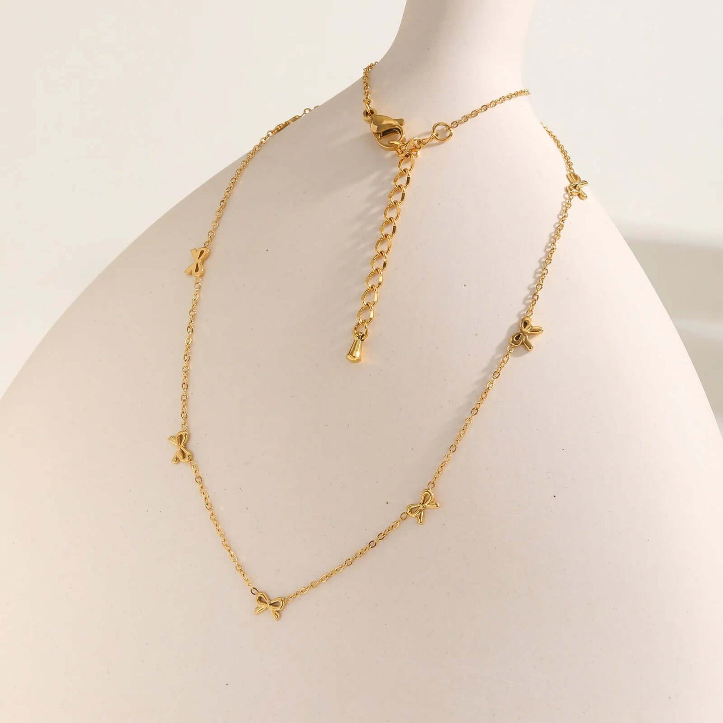 Collier nœud papillon en acier inoxydable plaqué or jaune variante incrusté sur une jarre.