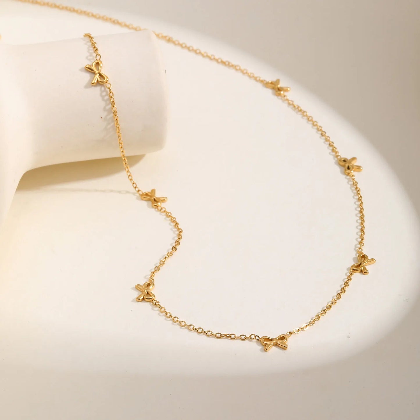 Collier nœud papillon en acier inoxydable plaqué or jaune variante incrusté à plat.