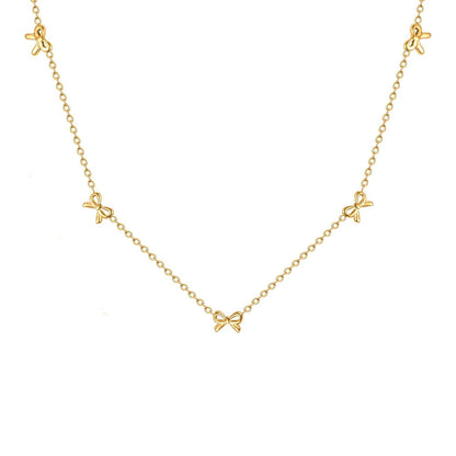 Collier nœud papillon en acier inoxydable plaqué or jaune variante incrusté sur fond blanc.