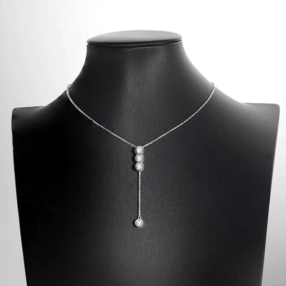Collier pendentif en or blanc et diamants synthétiques porté sur un mannequin.