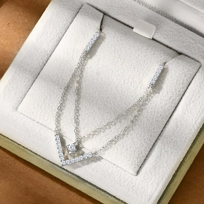 Collier pendentif V maille double en argent 925 plaqué or blanc et moissanites rangé dans son écrin vue du dessus.