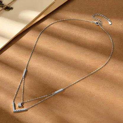 Collier pendentif V maille double en argent 925 plaqué or blanc discret et moissanites à plat vue de côté.