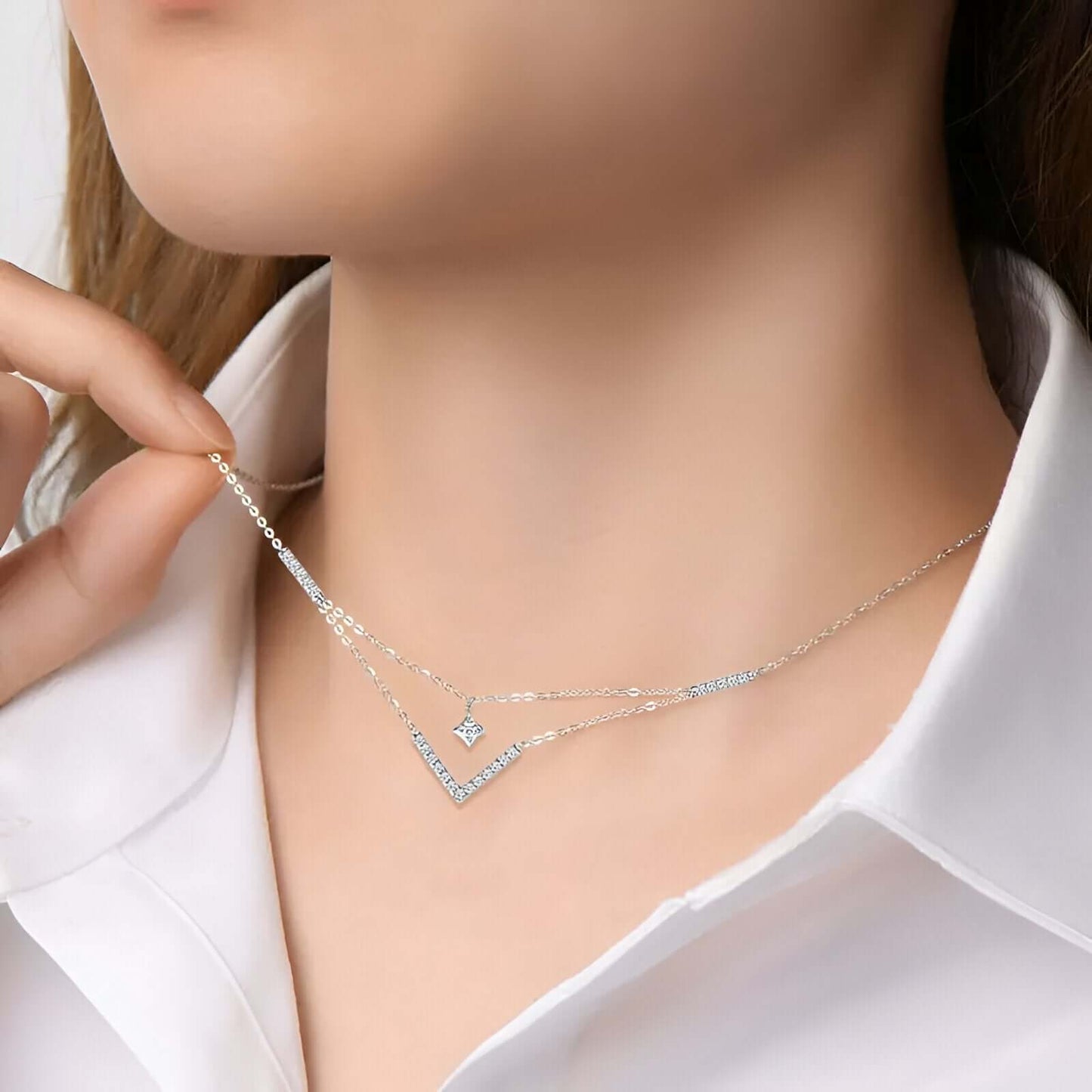 Collier pendentif V maille double en argent sterling 925 plaqué or blanc et moissanites porté au cou d'une femme.