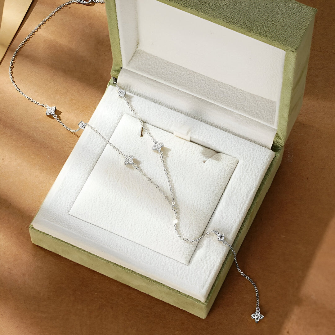 Collier sautoir en or blanc et diamants synthétiques sur son écrin.