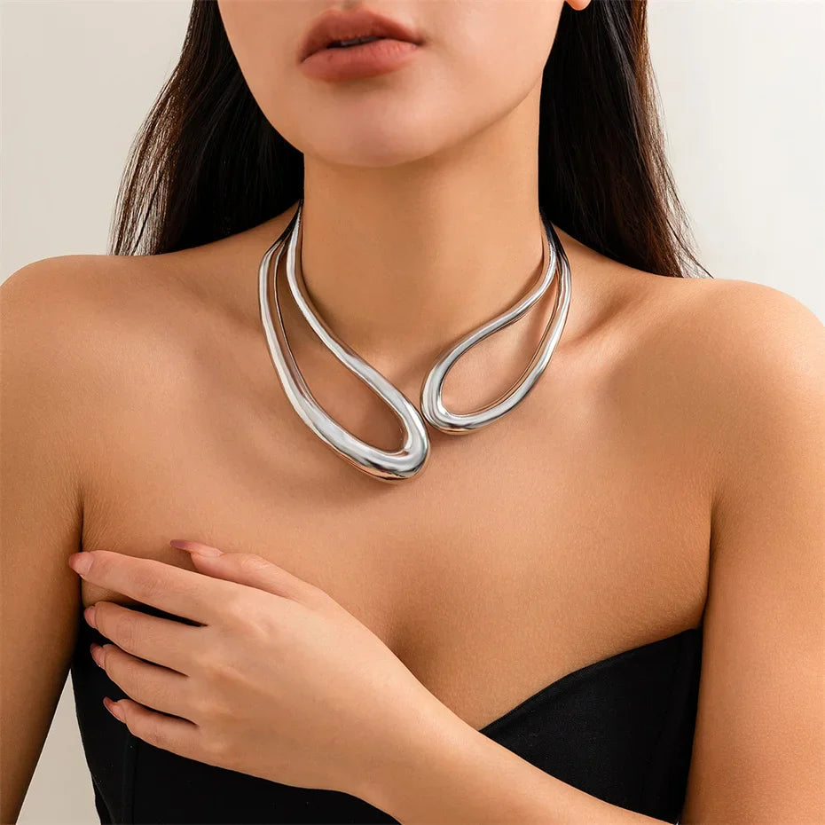 Collier torque goutte d'eau en or blanc porté au cou d'une femme.