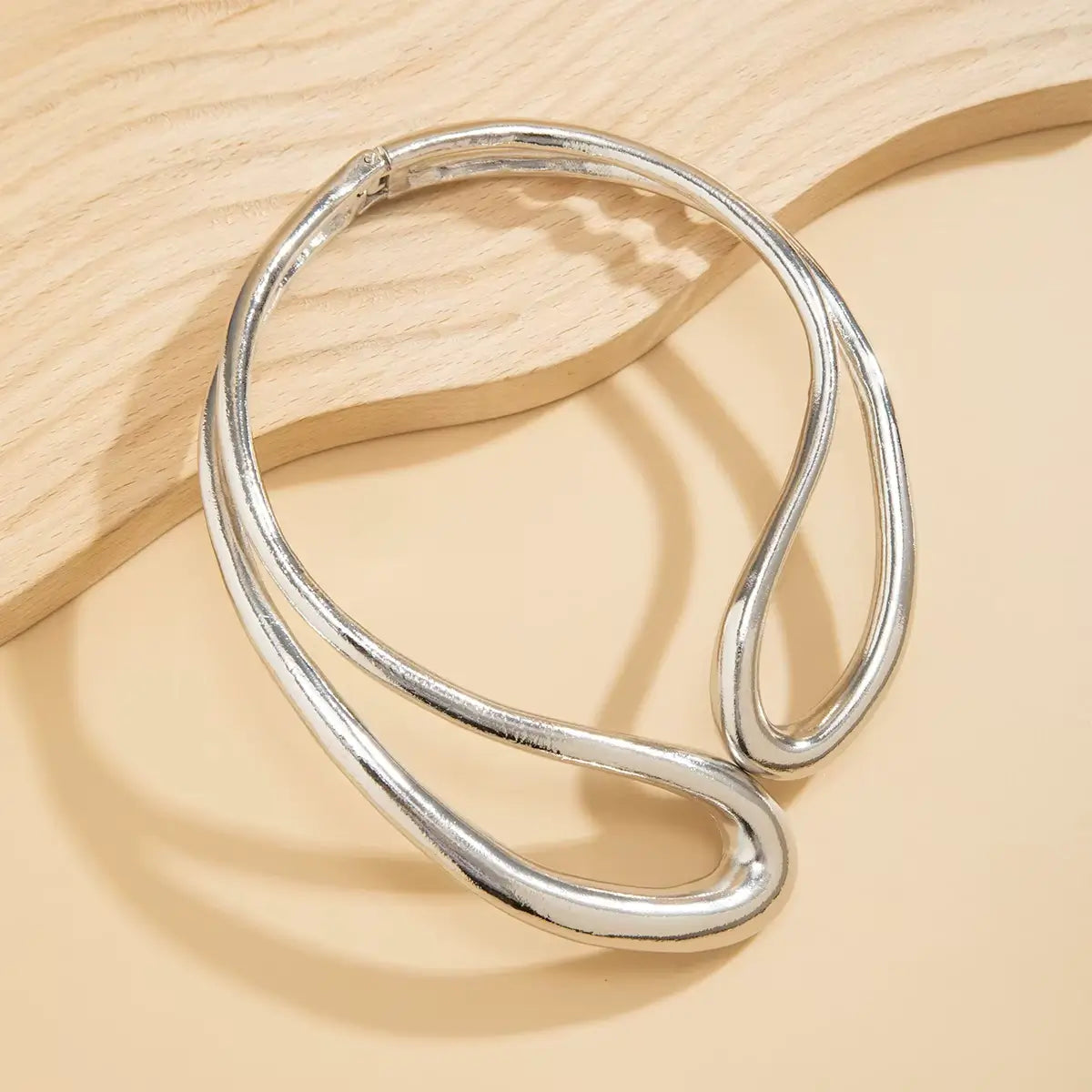 Collier torque goutte d'eau en or blanc posé.