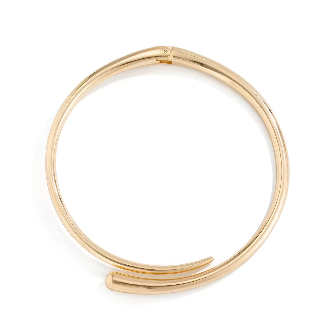 Collier torque goutte d'eau en or jaune sur fond blanc.