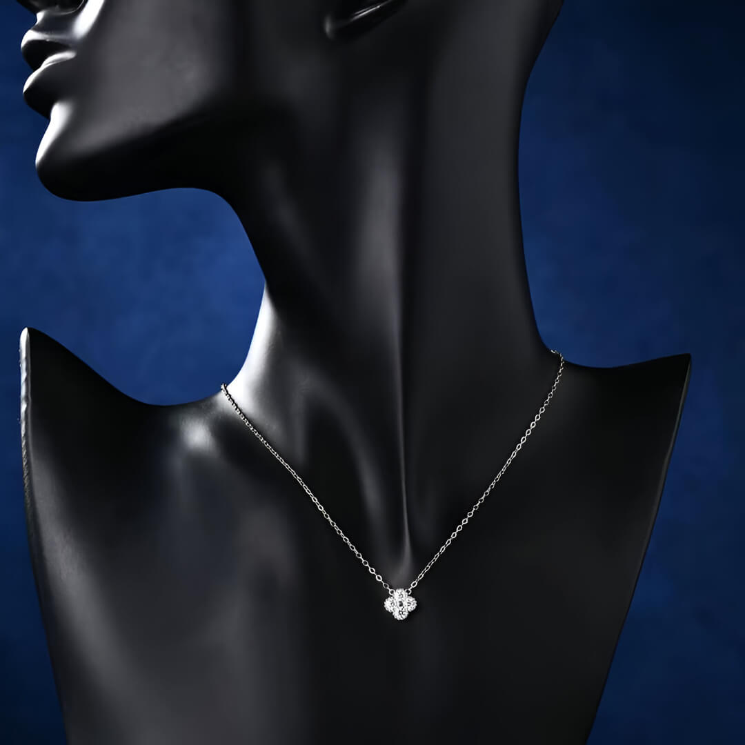 Collier trèfle à quatre feuilles en argent 925 plaqué or blanc délicat et moissanites porté par un mannequin vue de face.