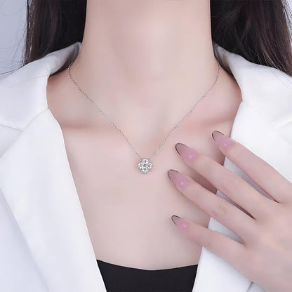 Collier trèfle à quatre feuilles en argent 925 plaqué or blanc et moissanites scintillantes porté au cou d'une femme.