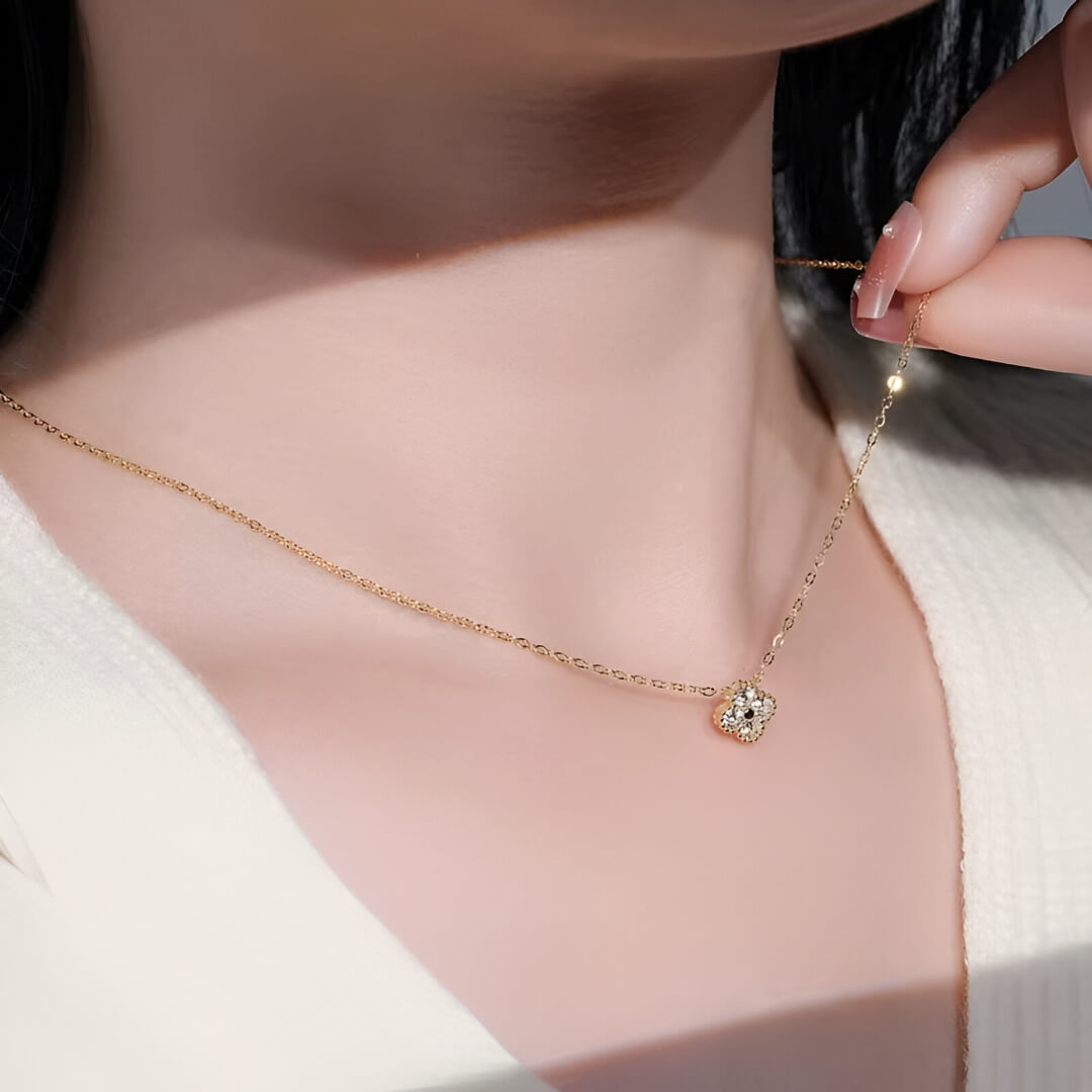 Collier trèfle porte-bonheur en argent 925 plaqué or jaune et diamants éclatants porté au cou d'une femme vue de côté.