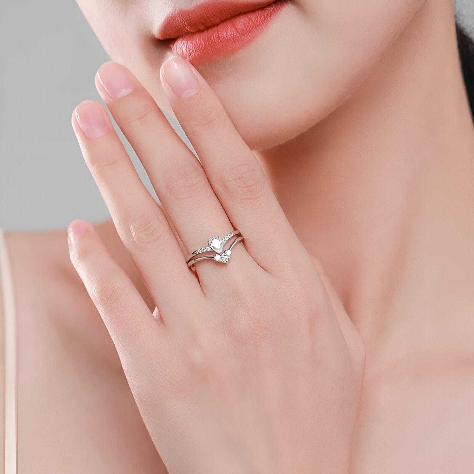 Double bague de fiançailles empilade Laurie en argent 925 rhodié et diamants étincelants portée au doigt d'une femme vue de proche.