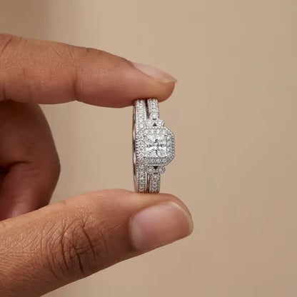 Duo de bagues de fiançailles accumulation Liora en argent 925 plaqué or blanc et diamants étincelants entre les doigts d'une femme vue de face.