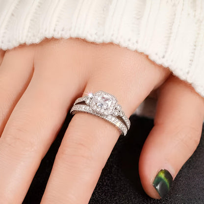 Duo de bagues de fiançailles accumulation Liora en argent 925 plaqué or blanc raffiné et diamants porté au doigt d'une femme vue de proche.