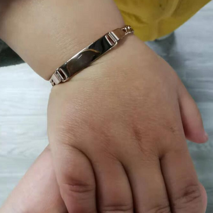 Gourmette chaîne cubaine ajustable en acier plaqué titane portée au poignet d'un bébé.