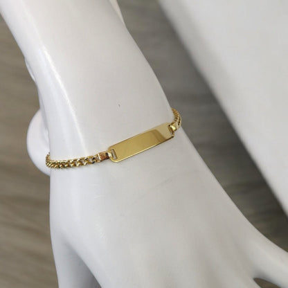 Gourmette chaîne cubaine ajustable en acier doré portée au poignet d'un mannequin.