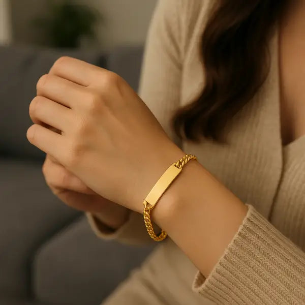 Gourmette maille cubaine en acier plaqué or jaune porté au poignet d'une femme.