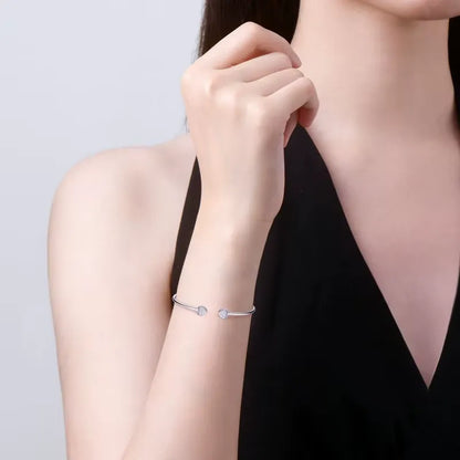 Jonc double cœur argenté Elvaëlys en argent 925 plaqué or blanc discret et moissanites porté au poignet d'une femme.