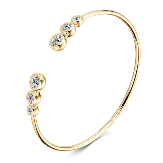 Jonc fin serti clos en argent 925 plaqué or jaune et diamants sur fond blanc.