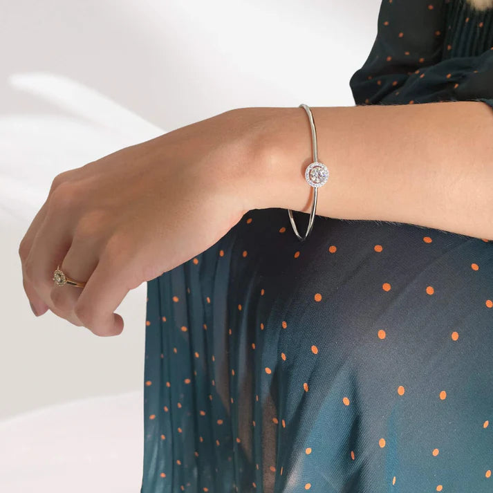 Bracelet jonc halo solitaire en argent 925 plaqué or blanc et diamants porté au poignet d'une femme vue sur le côté.