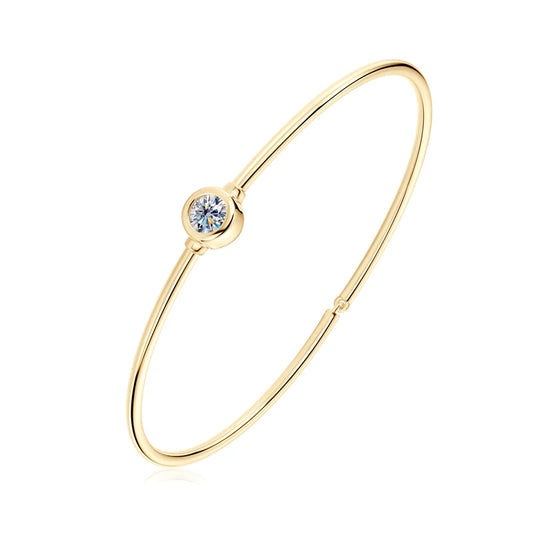 Jonc solitaire fin en argent 925 plaqué or jaune et diamant serti clos sur fond blanc.
