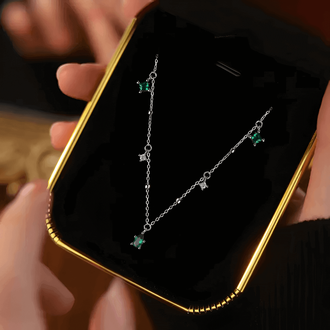 Pendentif à breloques en or blanc et diamants naturels dans son écrin.