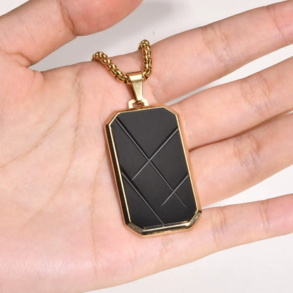 Pendentif amulette en acier inoxydable doré sur une main vue de face.