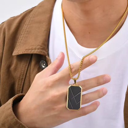 Pendentif amulette en acier inoxydable doré porté au cou d'un homme.