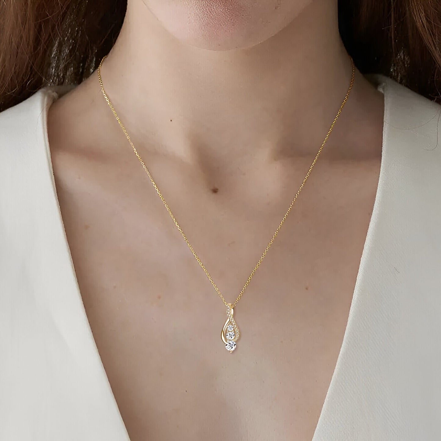 Pendentif cascade sinueux Rhyta en argent 925 plaqué or jaune et diamants étincelants porté au cou d'une femme vue de face.