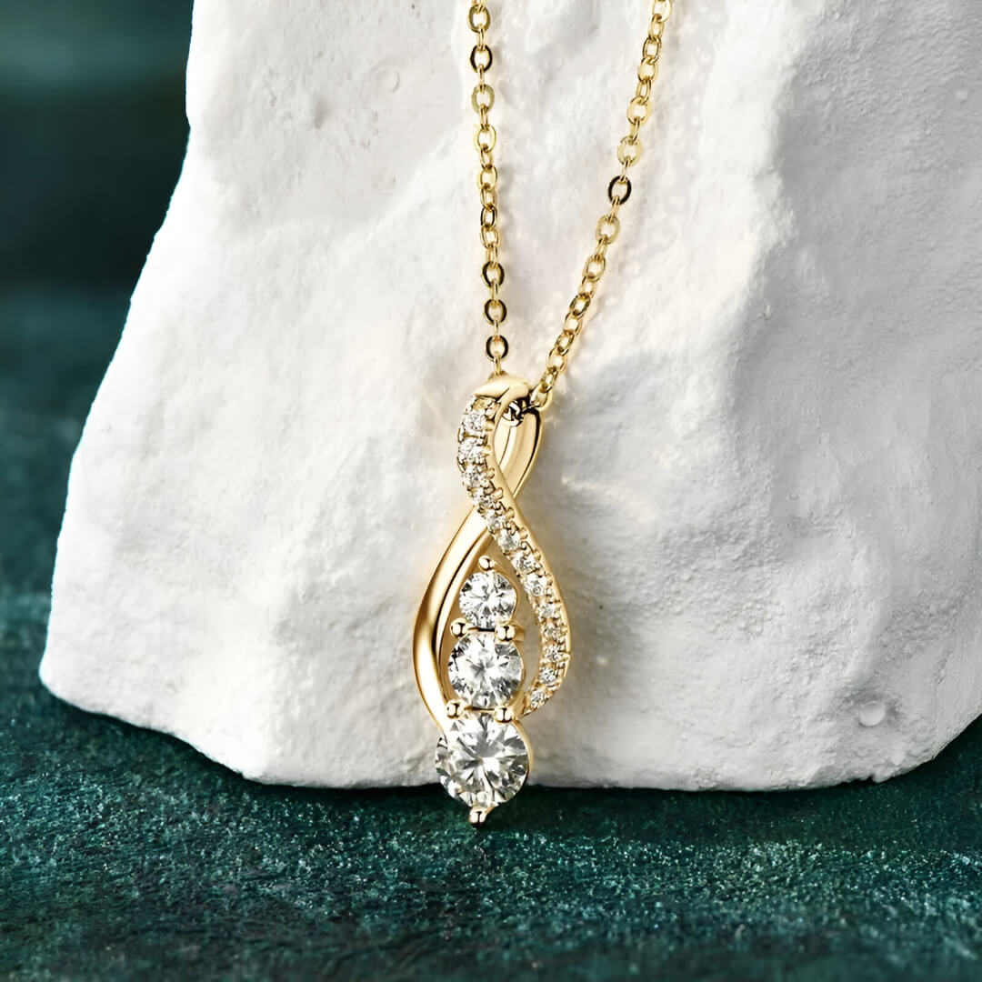 Pendentif cascade sinueux Rhyta en argent sterling 925 plaqué or jaune et diamants posé sur une pierre blanche vue de face.