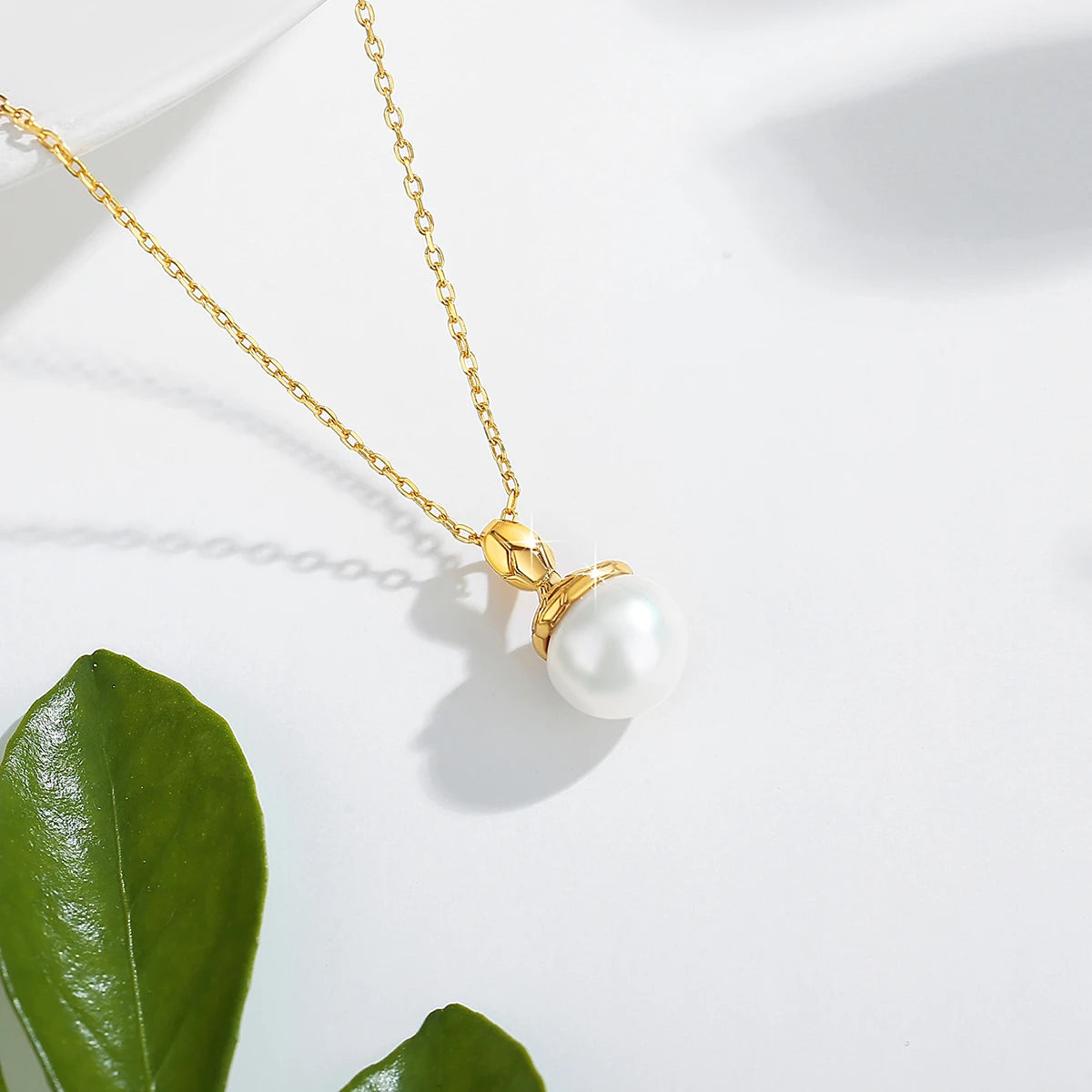 Pendentif cobra doré Sarah en or jaune 18K et perle naturelle ovale nacrée vue du dessus.