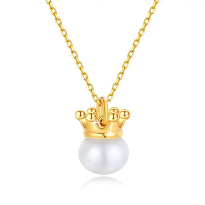 Pendentif couronne du roi Louis en or jaune 18K et perle naturelle sur fond blanc.