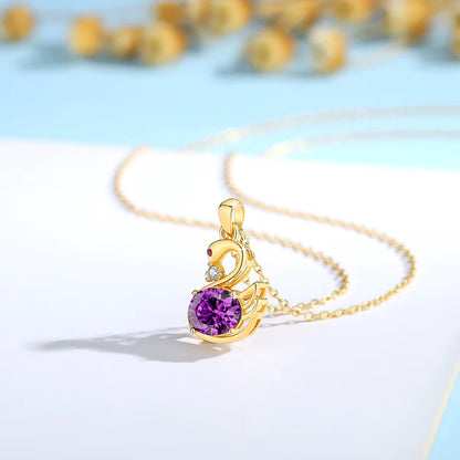 Pendentif cygne améthyste en or jaune orné d'un rubis et d'un diamant naturel debout.