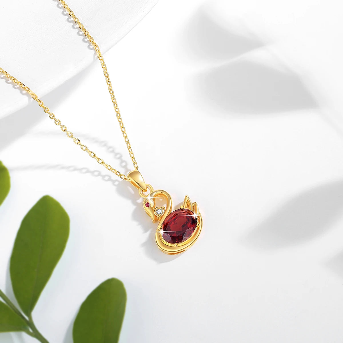 Pendentif cygne grenat romantique en or jaune 18K serti d'un diamant étincelant et d'un rubis vue du dessus.